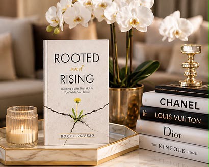 Rooted and Rising, the book standing against draped velvet with its dandelion cover